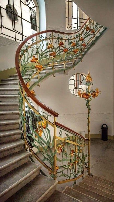 fotografia de unas escaleras decoradas con flores amarillas y anaranjadas a el estilo art nouveau